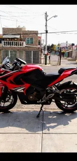 Sleek red sports bike parked on urban street.