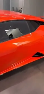 Sleek red sports car in a showroom setting.