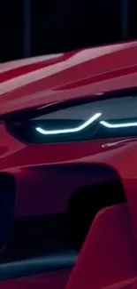 Close-up of a sleek red sports car with modern LED headlights.