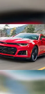 Sleek red sports car speeding on a scenic road.