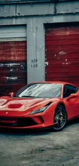 Red sports car parked in front of a garage with red doors.