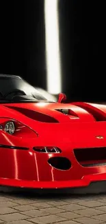 Sleek red sports car against a dark background with dramatic lighting.