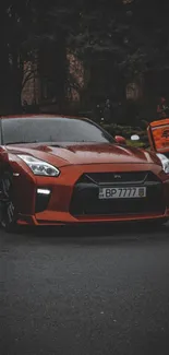 Red sports car on a dimly lit street, showcasing sleek design and style.