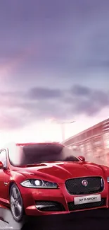 Red sports car speeding in an urban setting with a bright sky.