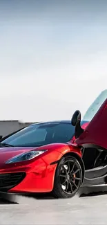 Sleek red sports car with open doors on display.