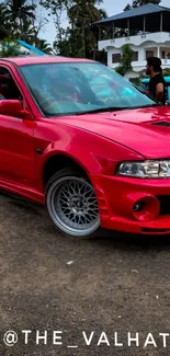 Red sports car parked outdoors with stylish design and shiny finish.