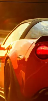 Sleek red sports car at sunset background.