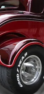 Glossy red vintage car with detailed wheels and sleek design.