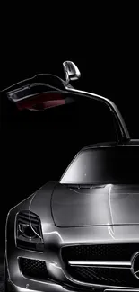 Sleek silver car with gullwing door on black background.