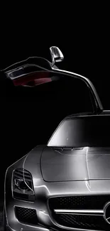 Sleek silver car with gullwing doors on a dark background.