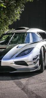 Sleek silver supercar parked on a scenic road.