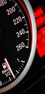 Close-up of a sleek car speedometer with red and black dials.