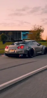 Sleek sports car driving at sunset on scenic road.