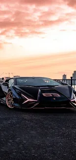 Sleek black sports car with sunset backdrop.