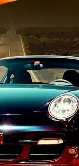 Sleek sports car on an open road at sunset with orange sky.