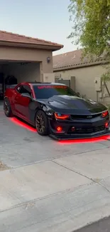 Black sports car with red lights on driveway.