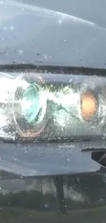 Close-up of sleek sports car headlight in rain.