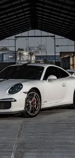 Sleek white sports car in a spacious warehouse with industrial vibes.