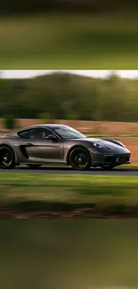 Sleek sports car driving on a scenic road with blurred background.