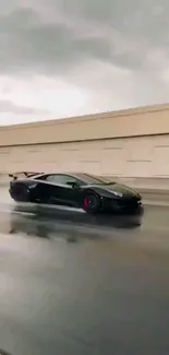 Black sports car speeding on a rainy highway road.