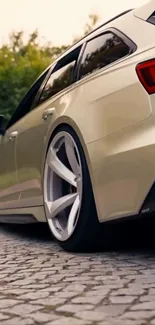 Sleek rear view of a beige sports car on a paved road.