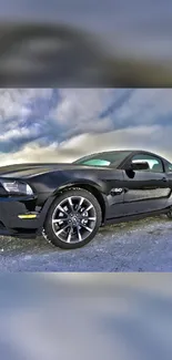 Sleek black sports car against dynamic sky.