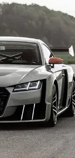 Sleek gray sports car on open road.