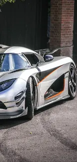 Silver sports car parked in a driveway with lush greenery around.