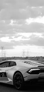 Black and white sports car wallpaper with cloudy sky background.