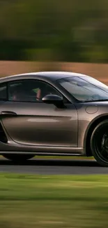 Sleek dark gray sports car on a track in motion.