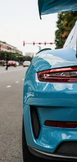 Blue sports car on urban road with cityscape background.