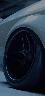 Close-up of a sleek car wheel with a dark aesthetic.