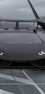 Sleek black sports car with jets on a runway.