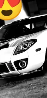 Black and white sportscar with heart eyes emoji overlay.