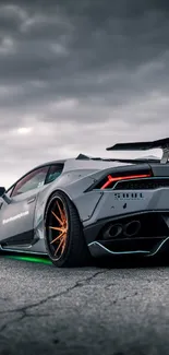 Sleek supercar on open road under dramatic skies.