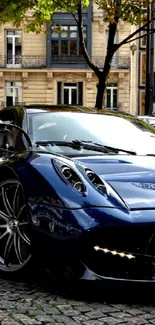 Dark blue supercar parked on a cobblestone street in the city.