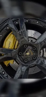 Close-up of a glossy black supercar wheel with intricate detailing.