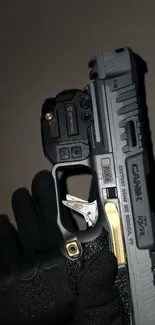 Close-up of a sleek gray gun with gold accents.