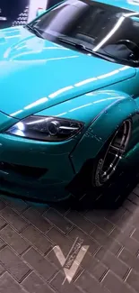 Sleek teal sports car on brick road.