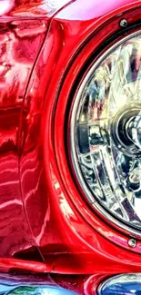 Close-up of a vintage car's glossy red headlight.