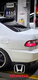 Sleek white Honda parked at a gas station with visible logo.