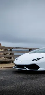 Sleek white sports car on a scenic roadway.