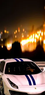 White sports car with blue stripes in city lights background.