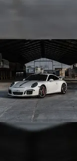 White sports car in a modern industrial setting, perfect for mobile wallpaper.