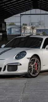 White sports car in urban garage setting.