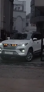 Sleek white SUV parked in a cityscape background.