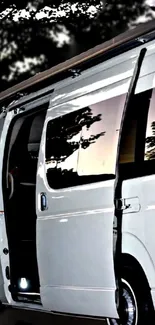 White van with open door, reflecting trees.