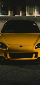 Sleek yellow car in a dimly lit setting, perfect for wallpaper.