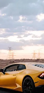 Sleek yellow sports car driving in a scenic desert with a cloudy sky.