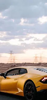Yellow sports car on a desert highway under a cloudy sunset sky.
